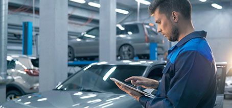 Mitarbeiter-mit-einem-Tablet-in-einer-Autowerkstatt