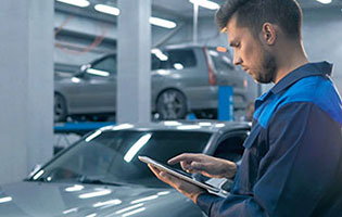 Mitarbeiter-mit-einem-Tablet-in-einer-Autowerkstatt