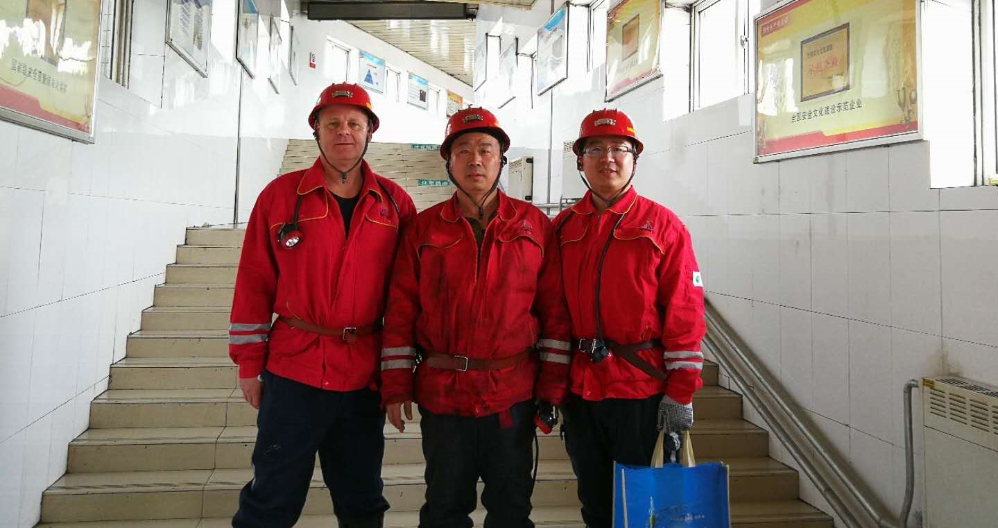 Drei Personen in roten Bergbauanzügen